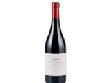 a bottle of red wine sitting on top of a white surface