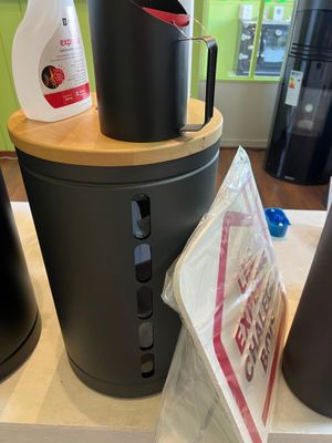 a black trash can sitting on top of a counter next to a black trash can