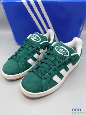 Chaussures adidas Superstar vertes et blanches, présentées dans une boîte bleue