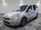 La camionnette argentée est garée sur un sol à damier dans un garage