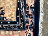 un tapis posé par terre, avec un chat assis dessus
