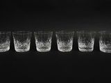 quatre verres à shot sont alignés sur un fond noir