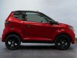 the red car is parked on the concrete floor in front of a white wall