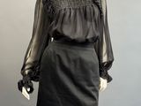 an image of a mannequin wearing a black dress with sheer sleeves
