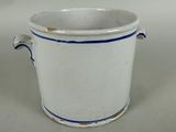 a white cup with blue trim on it on a white surface