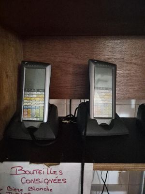 trois téléphones portables posés sur une étagère dans une pièce