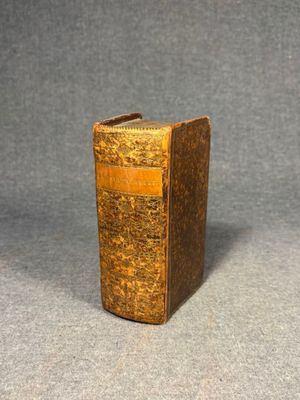an old book sitting on top of a table next to a gray background