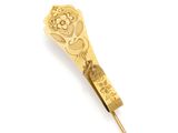 an image of a gold tie bar on a white background