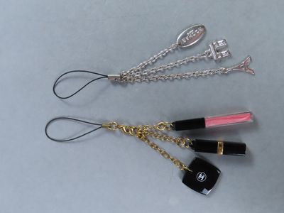 trois rouges à lèvres et un porte-clés posés sur une table