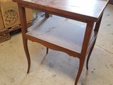 a small table with a shelf on it in a room