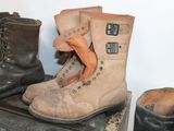 three pairs of boots sitting on top of a wooden box