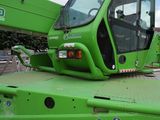 a green crane that is parked in a parking lot
