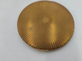 an image of a close up of a gold plate on a white surface