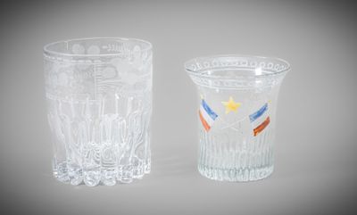 two shot glasses with different designs on them sitting next to each other
