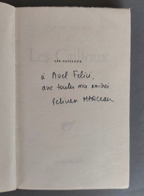 un livre ouvert posé sur une table, sur lequel se trouve une note manuscrite
