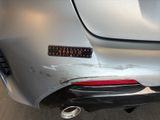 the rear end of a silver car with a sticker that says auto