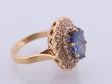 a close up of a ring with a tan sapphire and white diamonds