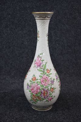un vase blanc orné de fleurs roses sur fond noir