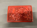 a red box with flowers on it sitting on a table