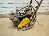 a close up of a machine with a yellow handle on a concrete floor