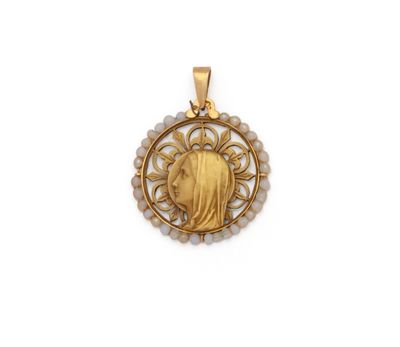 un pendentif plaqué or représentant un visage de femme entouré de perles