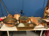 de nombreuses casseroles et poêles posées sur une table dans une pièce