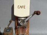 a small coffee grinder sitting next to a cup of coffee