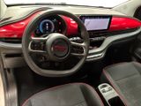 the interior of a red and black car with a steering wheel and dashboard