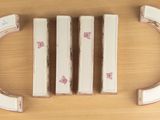 four pieces of white and pink painted furniture on a table