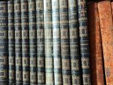 many old books on a wooden shelf in a library