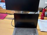un ordinateur portable posé sur un bureau, avec un écran posé dessus