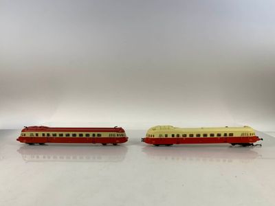 deux wagons rouges et jaunes placés côte à côte sur une surface blanche