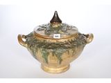 a green and brown bowl with a lid on a white table