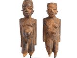 pair of african figurines of two men on wooden bases