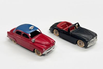 deux voitures jouets assises l'une à côté de l'autre sur une surface blanche