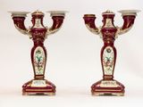 une paire de bougeoirs rouges et dorés ornés de motifs floraux