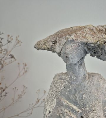 a statue of a woman with a bird on her head