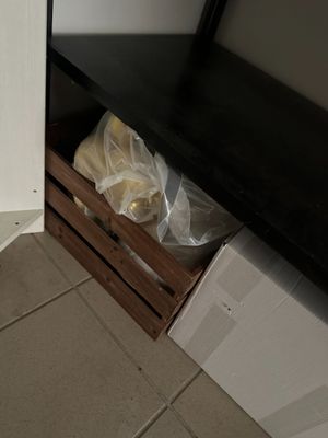 une étagère noire sur laquelle sont posés plusieurs sacs de provisions