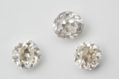 trois diamants de tailles et de formes différentes sur un fond blanc