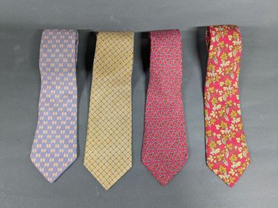 four different colored ties are lined up on a gray surface