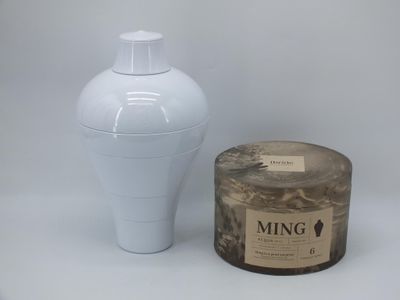 a picture of a white vase and a candle on a table