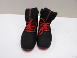 pair of black boots with red laces on a white surface