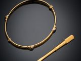 un bracelet en or et un bâton en bois sur fond noir