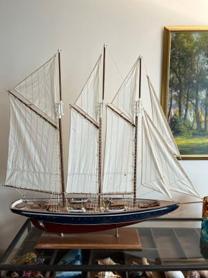 a small model of a sailboat on a glass table