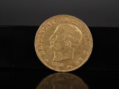 un gros plan d'une pièce d'or se reflétant sur une surface noire