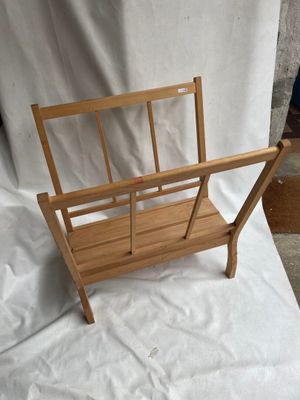 un porte-revues en bois posé sur un drap blanc, sur fond blanc