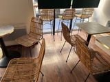de nombreuses chaises et tables dans une pièce au sol en parquet
