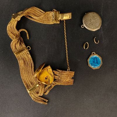 une image représentant un bracelet en or orné d'une pierre bleue et d'une chaîne en or