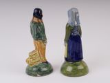 pair of ceramic figurines of a woman and a man with a basket