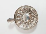 an antique silver plate with a stone in the center